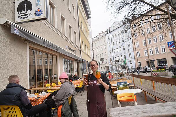 Zwei Tennis-Schiedsrichterstühle (hinten im Bild) zeichnen den Schanigarten der Bar München 72 aus. Mitarbeiterin Marie ist einsatzbereit.