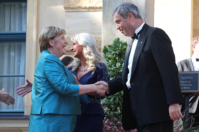 Angela Merkel (l, CDU), ehemalige Bundeskanzlerin, Markus Söder (r, CSU), Ministerpräsident von Bayern, und seine Frau Karin Baumüller-Söder (M). Angela Merkel (l, CDU), ehemalige Bundeskanzlerin, Markus Söder (r, CSU), Ministerpräsident von Bayern, und seine Frau Karin Baumüller-Söder (M).
