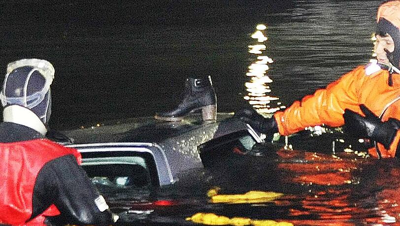 Ein Stiefel steht auf dem Autodach. Einsatzkräfte ziehen den Golf aus dem Tegernsee. Ein Stiefel steht auf dem Autodach. Einsatzkräfte ziehen den Golf aus dem Tegernsee.