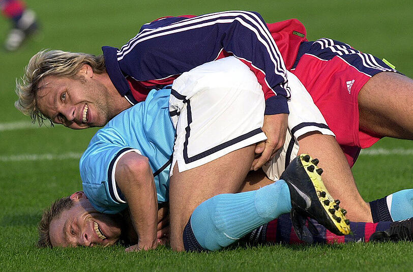 21. Oktober 2000: Bayern-Spieler Thorsten Fink (oben) und Thomas Häßler (unten) vom TSV 1860 liegen nach einem Zweikampf lachend am Boden.