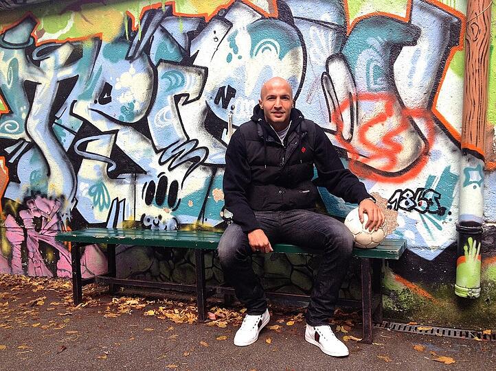 Löwen-Profi Necat Aygün am Bolzplatz an der Glockenbachwerkstatt. Hier, an der Corneliusstraße, verbrachte der Verteidiger früher viele Stunden seiner Kindheit - jetzt setzt er sich dafür ein, dass der Käfig-Platz erhalten bleibt