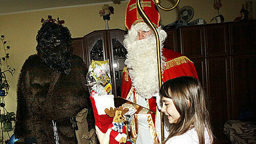 Besuch bei Familie Müller in Ramersdorf: Der Nikolaus lobt und verteilt Geschenke, im Hintergrund lauert der Krampus. Besuch bei Familie Müller in Ramersdorf: Der Nikolaus lobt und verteilt Geschenke, im Hintergrund lauert der Krampus.