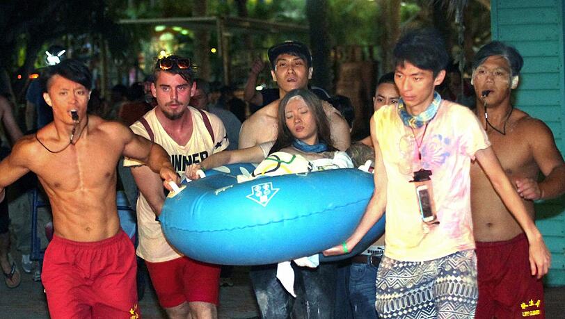 Ein riesiger Feuerball fegte über Besucher des "Formosa Water Park" in Taiwan hinweg. Helfer bringen eine junge Frau zu einem Krankenwagen. Ein riesiger Feuerball fegte über Besucher des "Formosa Water Park" in Taiwan hinweg. Helfer bringen eine junge Frau zu einem Krankenwagen.