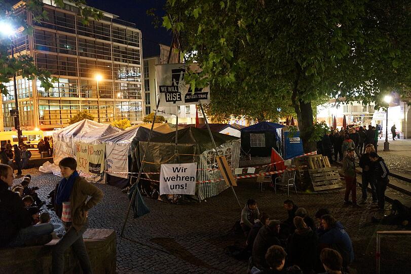 Polizisten und Notärzte stehen um das Camp am Rindermarkt. Seit Dienstag trinken die Protestierenden nichts mehr.