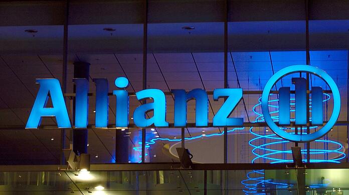 Das Logo der Allianz-Versicherung leuchtet am Abend über dem Haupteingang der Niederlassung in Frankfurt/Main.