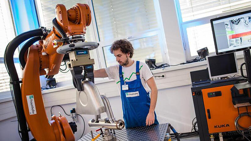 "Future Work Lab" des Fraunhofer Instituts in Stuttgart: Ein Roboterarm transportiert schwere Produktionsgegenstände, um Mitarbeiter zu entlasten.
