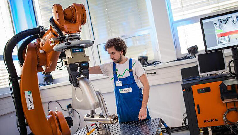 "Future Work Lab" des Fraunhofer Instituts in Stuttgart: Ein Roboterarm transportiert schwere Produktionsgegenstände, um Mitarbeiter zu entlasten. "Future Work Lab" des Fraunhofer Instituts in Stuttgart: Ein Roboterarm transportiert schwere Produktionsgegenstände, um Mitarbeiter zu entlasten.