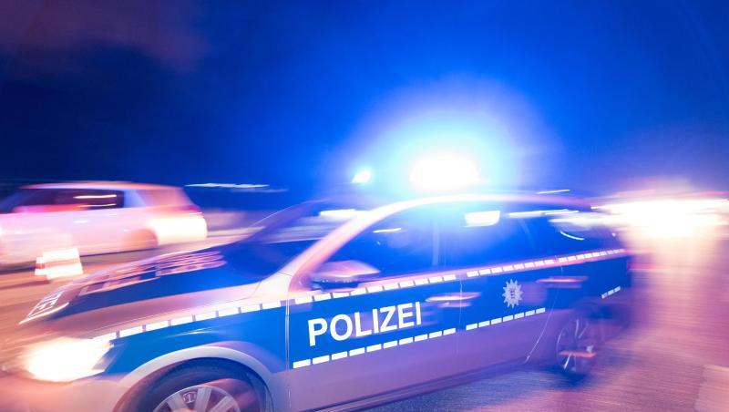 Ein Polizeifahrzeug steht mit Blaulicht auf der Straße. Ein Polizeifahrzeug steht mit Blaulicht auf der Straße.