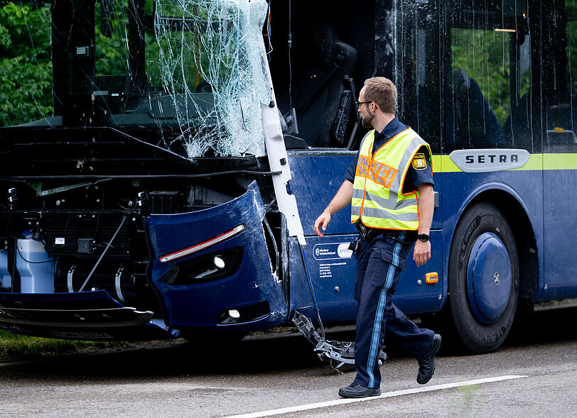 Ein Linienbus steht nach dem Zusammensto&szlig; mit einem anderen Bus besch&auml;digt auf der Stra&szlig;e.
