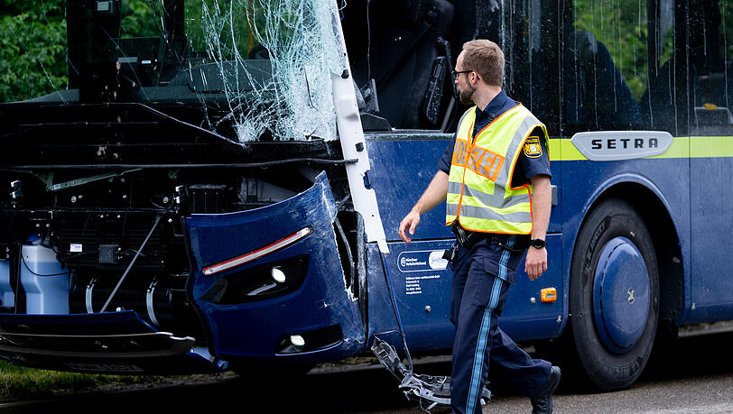 Ein Linienbus steht nach dem Zusammensto&szlig; mit einem anderen Bus besch&auml;digt auf der Stra&szlig;e.