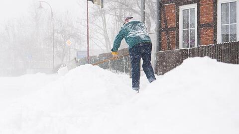 Mancherorts kam es zu heftigem Schneefall. Hier in der Region Hannover befreit ein Anwohner den Gehweg vor seinem Haus vom Schnee.