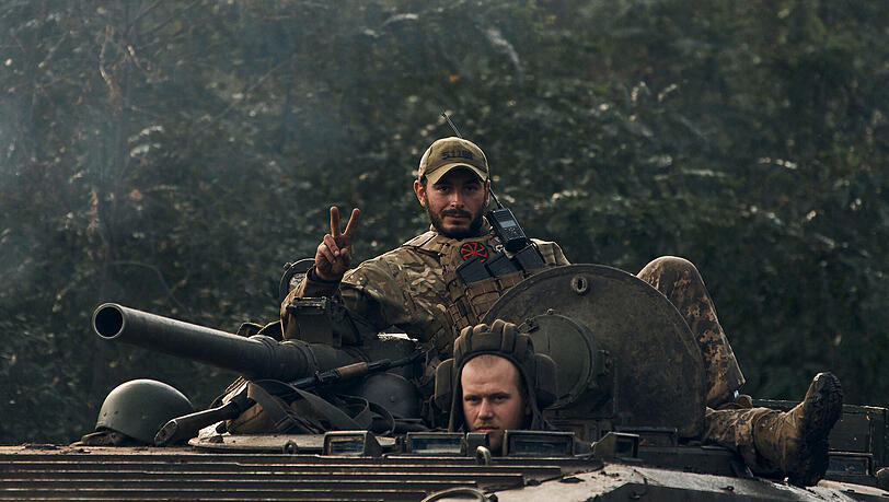 Ein ukrainischer Soldat zeigt ein Peace-Zeichen auf einem Fahrzeug in der Region Charkiw. Ein ukrainischer Soldat zeigt ein Peace-Zeichen auf einem Fahrzeug in der Region Charkiw.