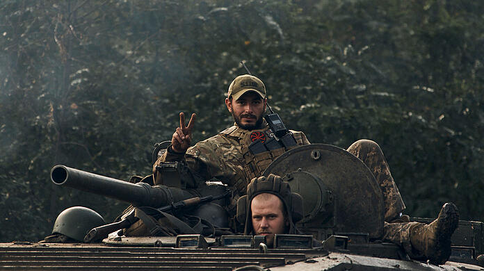 Ein ukrainischer Soldat zeigt ein Peace-Zeichen auf einem Fahrzeug in der Region Charkiw.