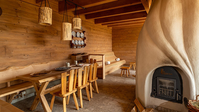 Tanken Sie Wärme in der mit Holz beheizten Wärmestube - durch die niedrigeren Temperaturen ist sie eine trockene, kreislaufschonende Sauna, die auch als sanfte finnische Sauna bezeichnet wird.