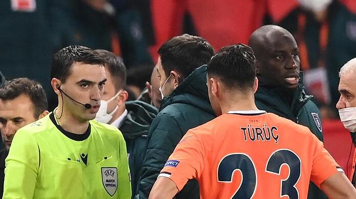 Der rumänische Schiedsrichter Ovidiu Hategan (l) diskutiert mit Verantwortlichen und Spielern von Istanbul Basaksehir und Paris Saint-Germain.