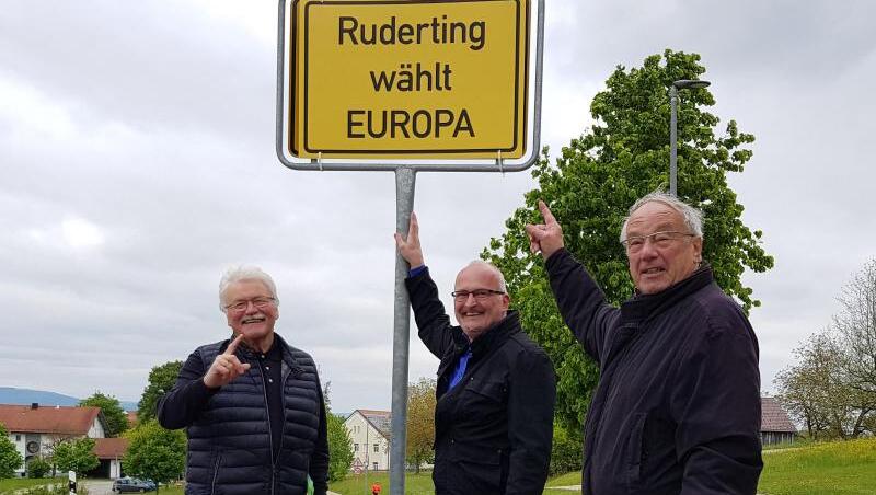 Konrad Kobler, Rudolf Müller und Joachim Rübenach stehen neben einem selbst gemachten Ortsschild mit der Aufschrift "Ruderting wählt Europa". Foto: Rudolf Müller Konrad Kobler, Rudolf Müller und Joachim Rübenach stehen neben einem selbst gemachten Ortsschild mit der Aufschrift "Ruderting wählt Europa". Foto: Rudolf Müller