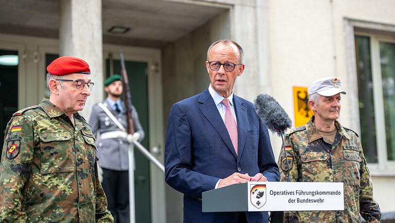 Kanzler Merz warnt vor falschem Sicherheitsgefühl und verlangt mehr Verteidigungsanstrengungen. Begrüßt wurde der CDU-Politiker von Carsten Breuer (l), Generalinspekteur der Bundeswehr, und Alexander Sollfrank (r), Befehlshaber des Führungskommandos.