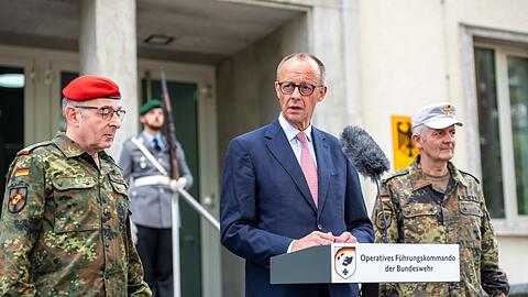 Kanzler Merz warnt vor falschem Sicherheitsgefühl und verlangt mehr Verteidigungsanstrengungen. Begrüßt wurde der CDU-Politiker von Carsten Breuer (l), Generalinspekteur der Bundeswehr, und Alexander Sollfrank (r), Befehlshaber des Führungskommandos.