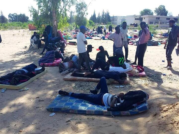 Migranten suchen nach einem Luftangriff auf ein Migrantenzentrum Schutz.
