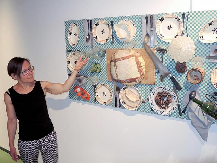 Die Programmverantwortliche des Museums Brot und Kunst, Marianne Honold, zeigt auf ein Werk von Daniel Spoerri. Foto: Thomas Burmeister