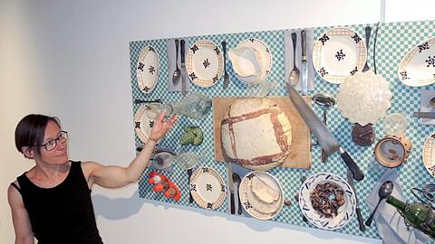 Die Programmverantwortliche des Museums Brot und Kunst, Marianne Honold, zeigt auf ein Werk von Daniel Spoerri. Foto: Thomas Burmeister