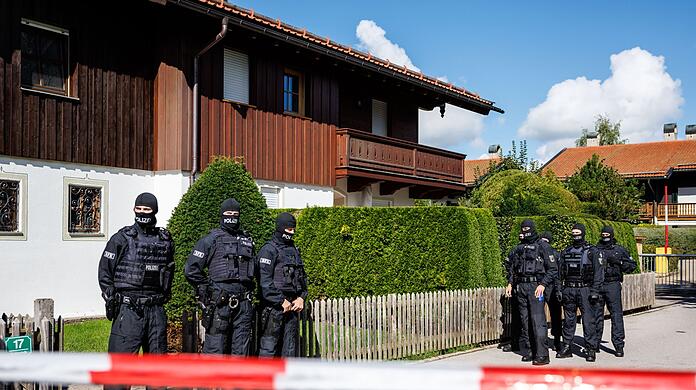 Maskierte Polizisten stehen bei einer Razzia vor einem Haus des russischen Oligarchen Usmanow.