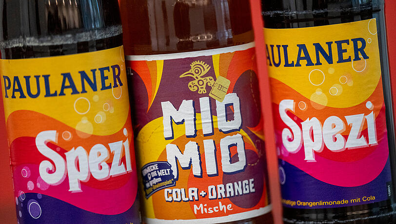 Zwei Spezi-Flaschen des Herstellers Paulaner stehen neben einer Flasche Mio-Mio-Cola-Orange-Mische (Mitte) des Herstellers Berentzen. Voraussichtlich am 5. August gibt es ein Urteil im Rechtsstreit zwischen Paulaner und Berentzen um das Farbdesign der Flasche.