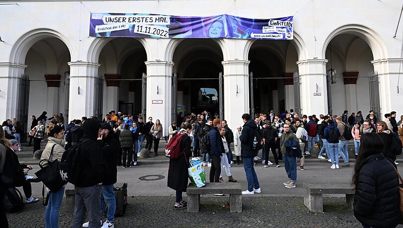 Studenten stehen vor dem Hauptgebäude der LMU.