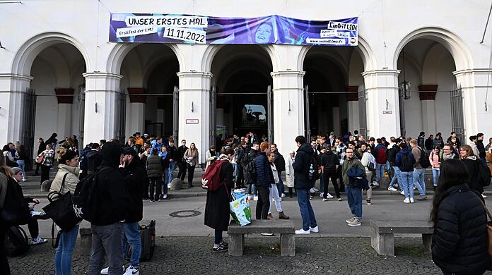 Studenten stehen vor dem Hauptgebäude der LMU.