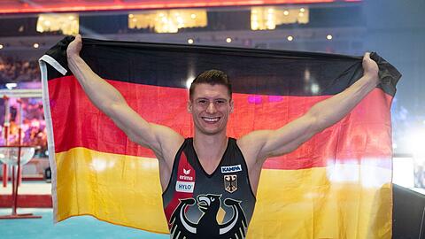 Lukas Dauser jubelt mit der deutschen Fahne.
