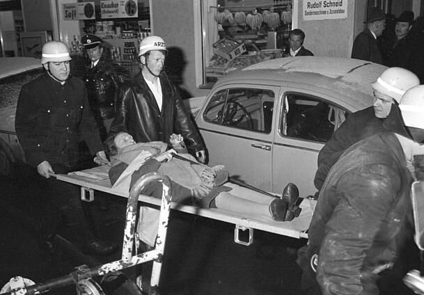 Eine Bewohnerin des Altenheims wird mit einer Rauchvergiftung ins Krankenhaus transportiert. Bei einem Großfeuer im Alten- und Fremdenheim der israelischen Kultusgemeinde (IKG) in München am 13.02.1970 sind sieben Menschen ums Leben gekommen. Ursache des Feuers war ein Brandanschlag. Eine Bewohnerin des Altenheims wird mit einer Rauchvergiftung ins Krankenhaus transportiert. Bei einem Großfeuer im Alten- und Fremdenheim der israelischen Kultusgemeinde (IKG) in München am 13.02.1970 sind sieben Menschen ums Leben gekommen. Ursache des Feuers war ein Brandanschlag.