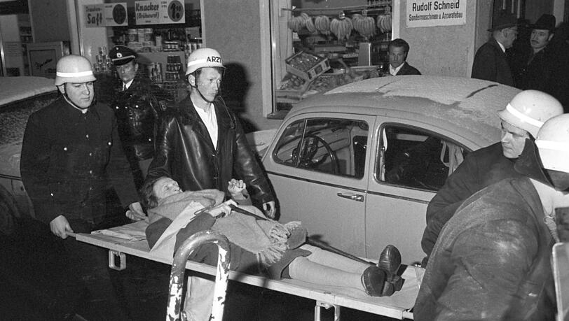 Eine Bewohnerin des Altenheims wird mit einer Rauchvergiftung ins Krankenhaus transportiert. Bei einem Gro&szlig;feuer im Alten- und Fremdenheim der israelischen Kultusgemeinde (IKG) in M&uuml;nchen am 13.02.1970 sind sieben Menschen ums Leben gekommen. Ursache des Feuers war ein Brandanschlag.