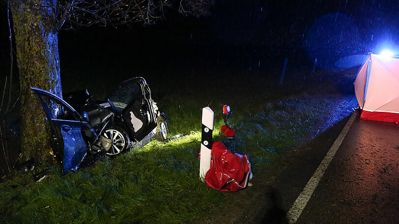Schreckliche Bilder aus Icking: Der BMW kam von der Straße ab und prallte gegen einen Baum. Zwei 19-jährige Männer starben.