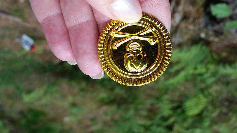 In diesem Fall sind es diese Goldtaler mit Totenkopfmotiv.