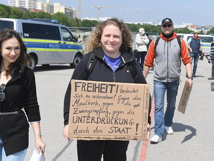 Eine Demonstrantin trägt ein Schild mit der Aufschrift "Freiheit bedeutet sich zu widersetzen! gegen ......". Foto: Felix Hörhager/dpa