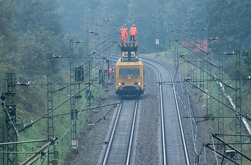 Arbeiter der Bahn reparieren die Oberleitung.