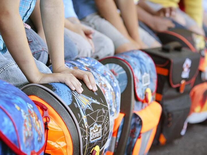 Schulkinder haben sitzend ihre Schulranzen vor sich zu stehen. Foto: David-Wolfgang Ebener/Archiv