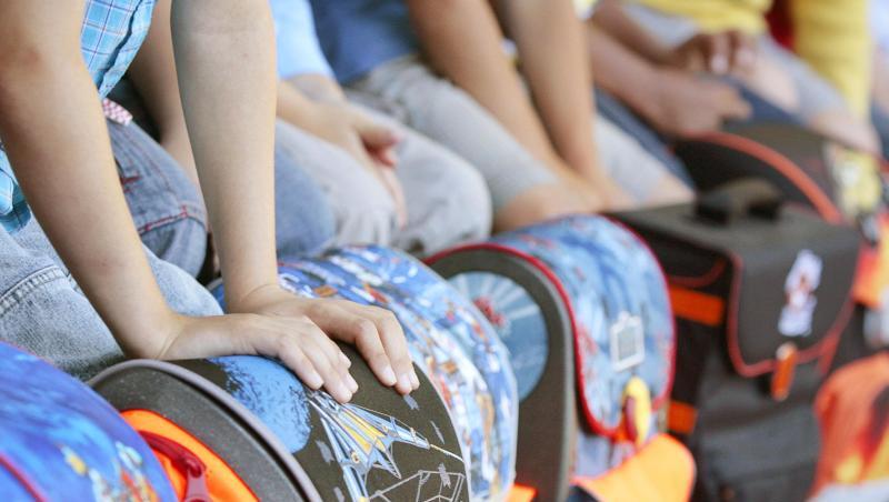Schulkinder haben sitzend ihre Schulranzen vor sich zu stehen. Foto: David-Wolfgang Ebener/Archiv