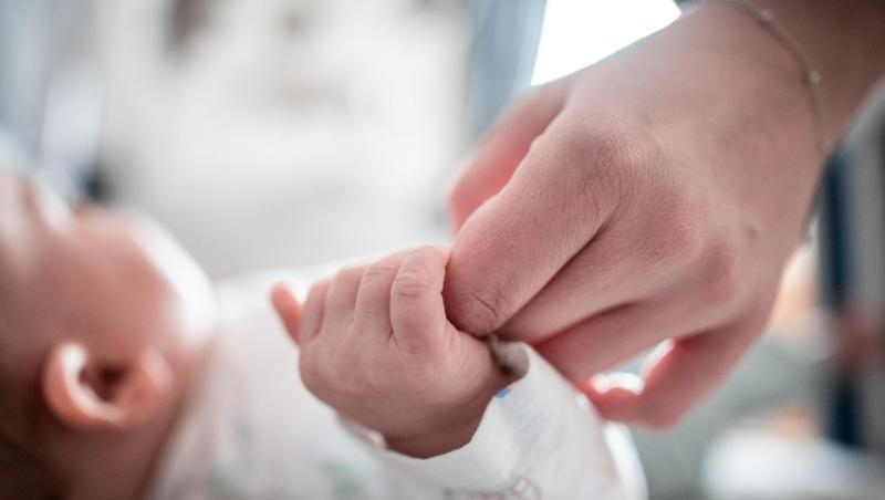 Ein Baby klammert sich an den Finger seiner Mutter. (Symbolbild)