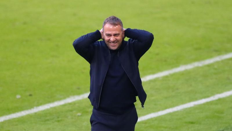 Münchens Trainer Hansi Flick fasst sich lächelnd an den Kopf.