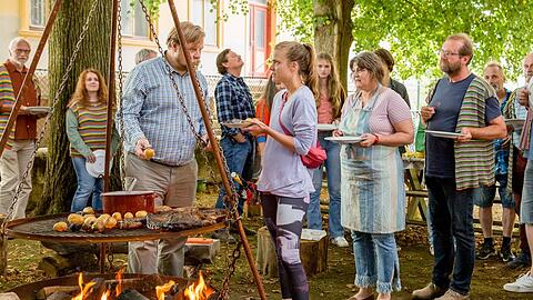 "Alles finster": Jens (Michael A. Grimm) steht am Grill und hat die Essenausgabe für die Dorfgemeinschaft - darunter Edi (Harald Windisch, r.v. Grimm), Laura (Miriam Fussenegger), Hermi (Elisabeth Leeb) - übernommen.