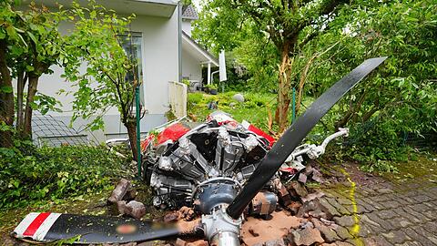 Ein Propeller der Maschine liegt vor einem Wohnhaus.