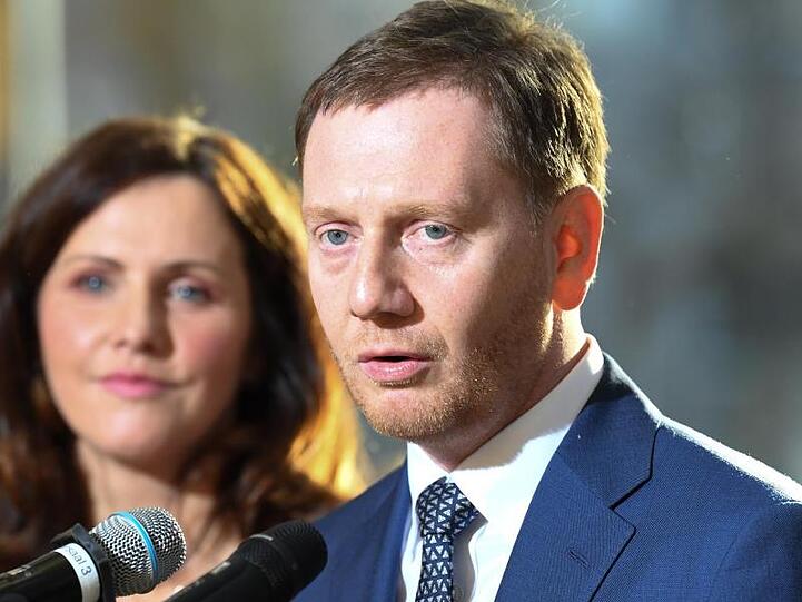 Ministerpräsident Michael Kretschmer (CDU) und seine Lebenspartnerin Annett Hofmann sprechen mit den Medien nach der Vereidiung im sächsischen Landtag.