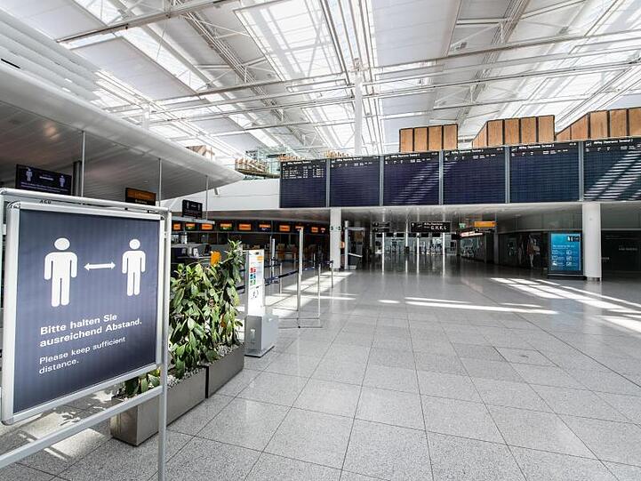 Ein Schild im fast menschenleeren Terminal vom Flughafen München. Foto: Matthias Balk/dpa