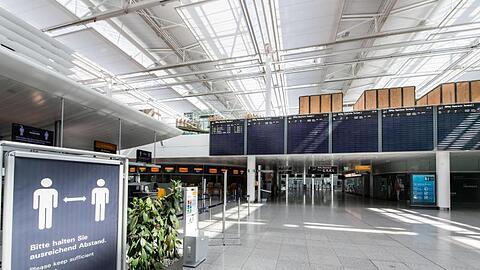 Ein Schild im fast menschenleeren Terminal vom Flughafen München. Foto: Matthias Balk/dpa