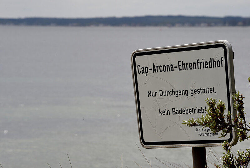 Schild weist am Strand von Neustadt zum Cap-Arcona-Ehrenfriedhof. Am 3. Mai 1945 bombardierten britische Flugzeuge drei Schiffe in der Lübecker Bucht, auf die die SS Tausende Gefangene aus Neuengamme gepfercht hatte. Bei dem Angriff aufgrund eines tragischen Irrtums der Briten starben 7000 Menschen.