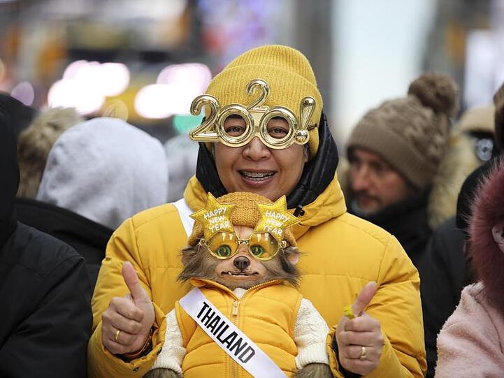 Eine Frau feiert mit ihrem Hund am Times Square in das neue Jahrzehnt.