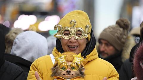 Eine Frau feiert mit ihrem Hund am Times Square in das neue Jahrzehnt.