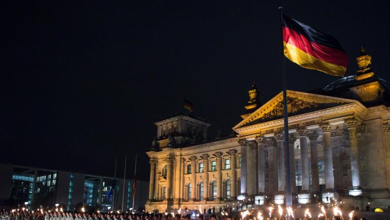 Zahlreiche Soldaten stehen bei einem Großen Zapfenstreich vor dem Reichstagsgebäude in Berlin.