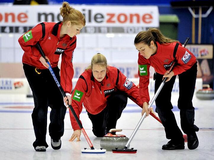 Andrea Schöpp (M) setzt den Stein, Stella Heiß (l) und Melanie Robillard wischen.